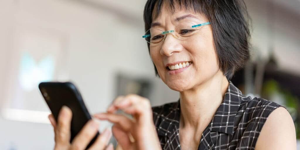 how-to-prevent-eye-problems-1024x512 Middle-aged woman wearing eye glasses, interacting on her mobile phone.