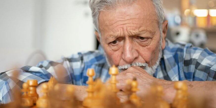 things-to-know-and-remember-md A senior man is thinking about his next chess move.